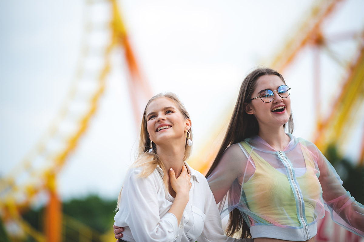 Two young females having a smile at the amusement park