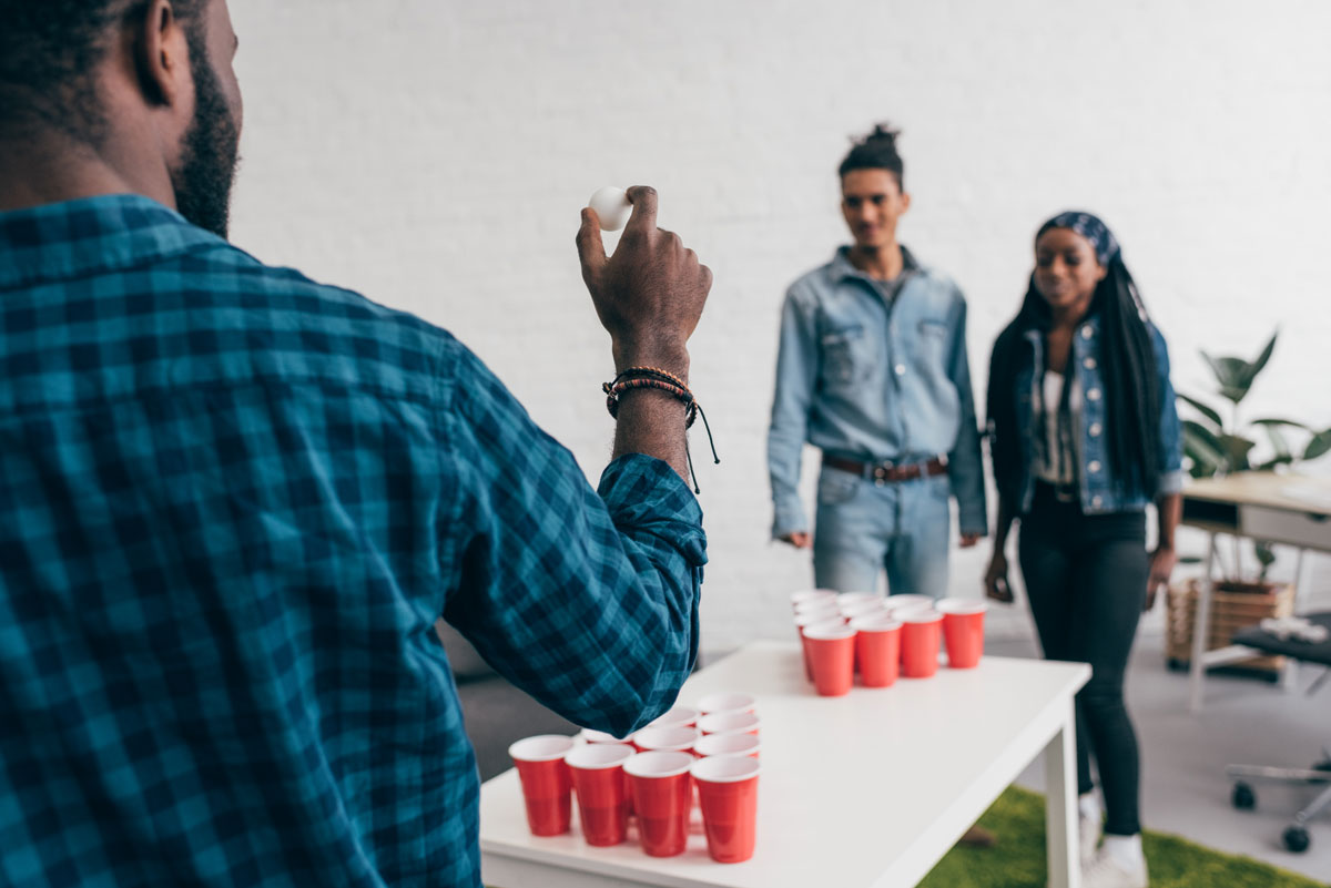 Group of diverse 20 something friends playing beer pong