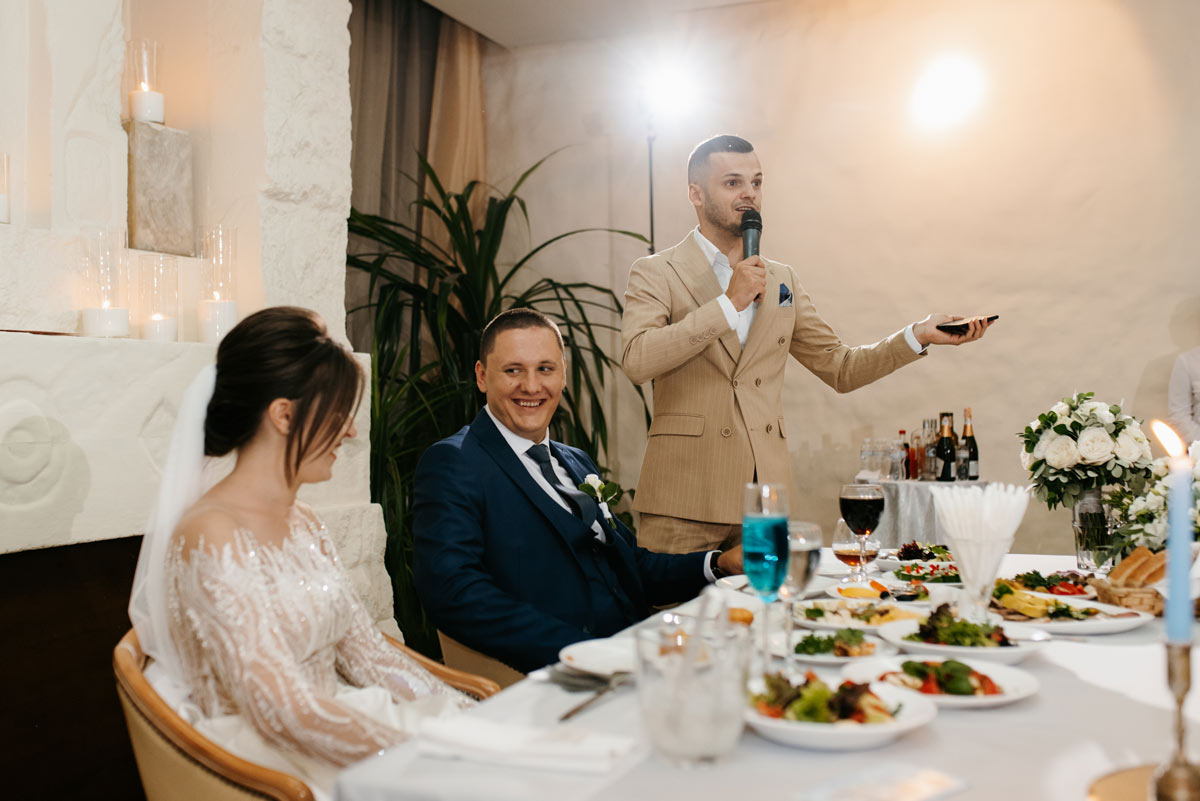 White 30-something best man making a speech to the newly wedded couple at the reception. 