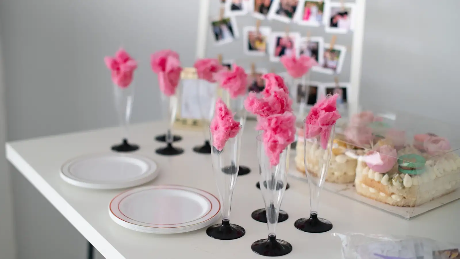 Elegant dessert table with pink cotton candy drinks and photo display for a 90th birthday celebration