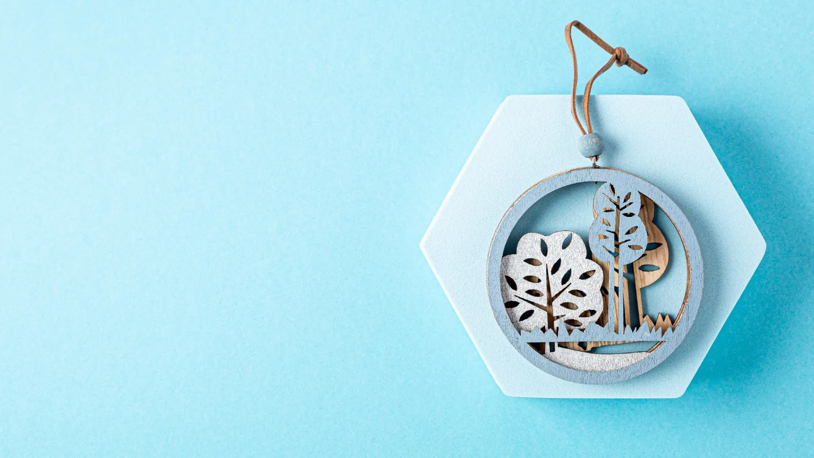 Family reunion gift and favor idea featuring a handmade wooden ornament with tree design on a light blue background