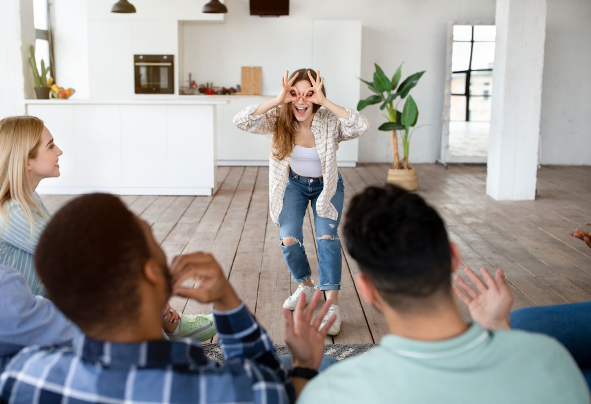 Diverse Cheerful millennial friends playing a charades game together