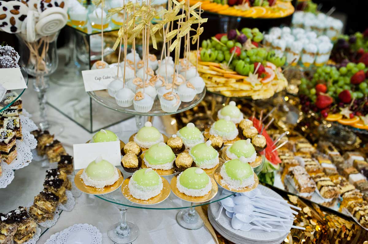 Elegant dessert buffet at a wedding reception, featuring an array of cupcakes and sweets to cater to guests.