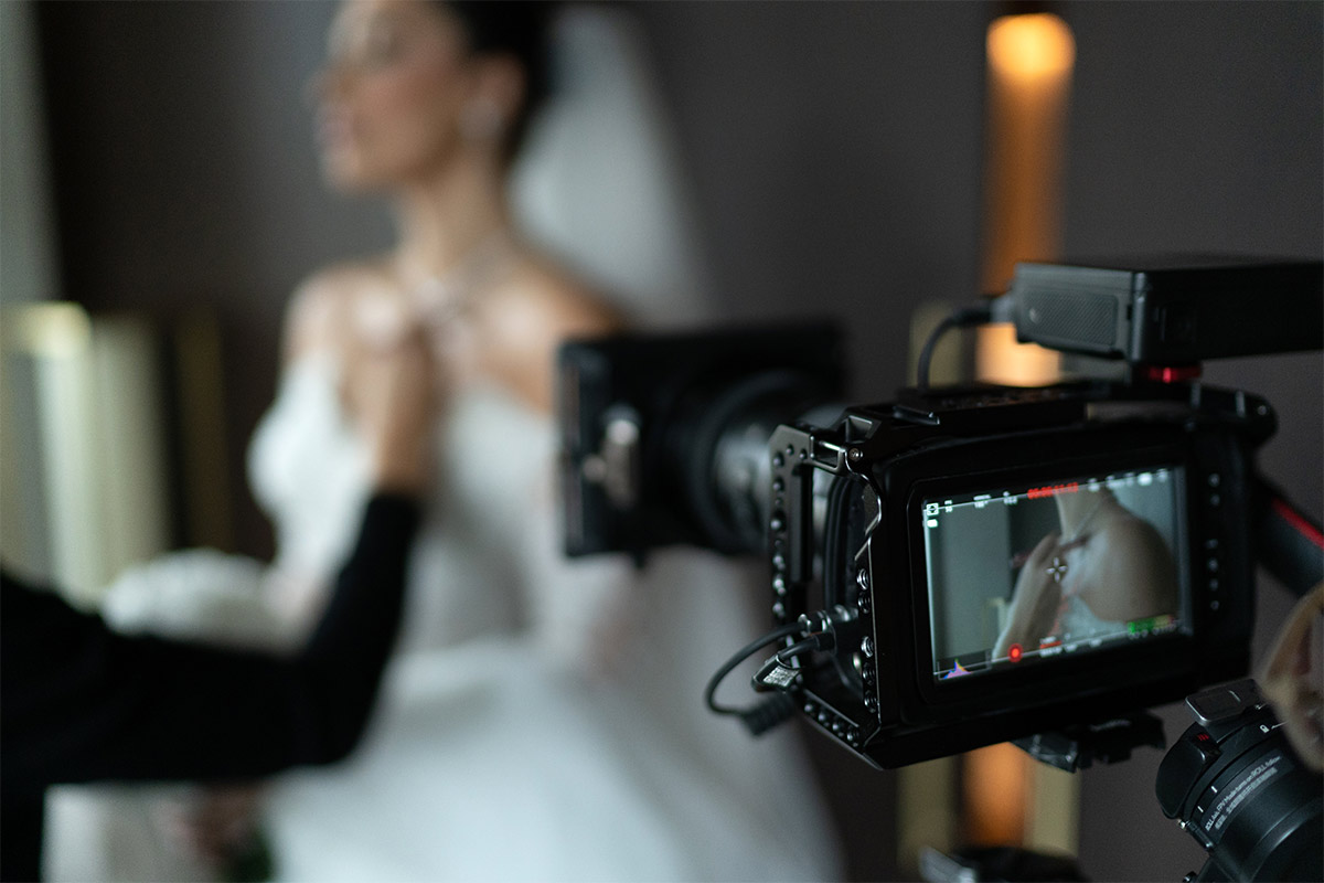 Camera taking video of a white bride in her wedding dress getting ready on her wedding day.