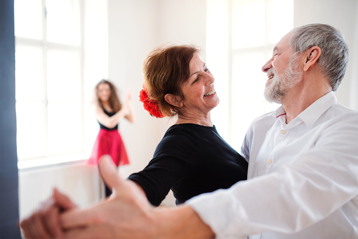 A senior adult couple in a dance class with a professional instructor highlighting the importance of finding the right dance studio for wedding dance preparation.