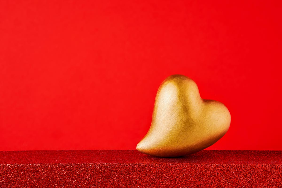 A golden heart with a red background. 