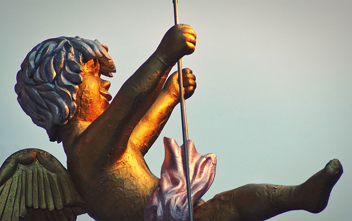 golden toddler angel smiling with wings swinging on a golden swing holding onto golden strings facing the right