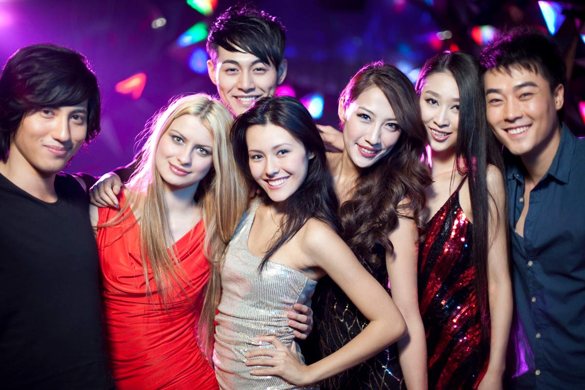 A group of seven mixed-race 21-year-old friends hanging out in a club. 