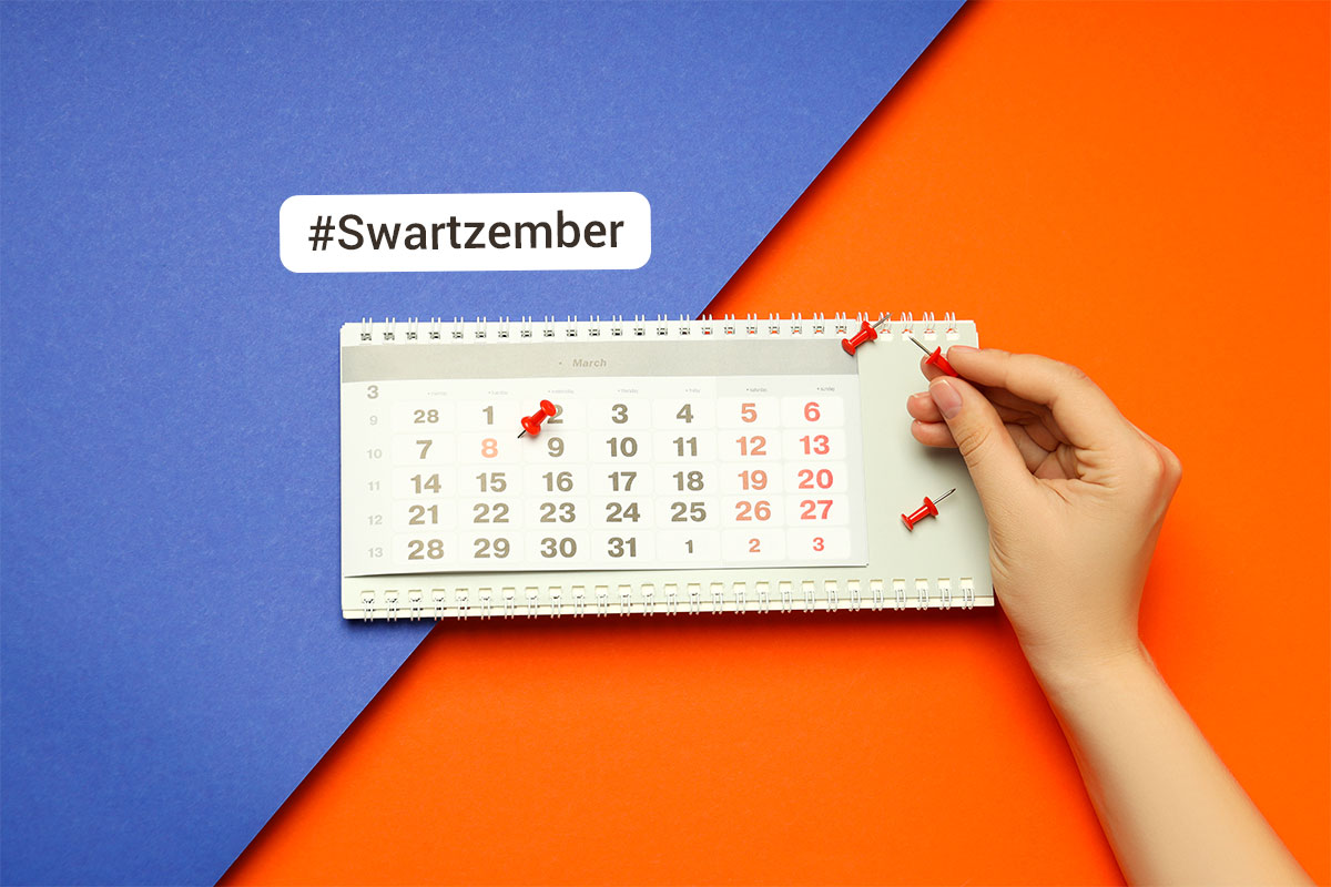 white person holds a pushpin over a calendar that already has three pushpins in it in front of a blue and orange background