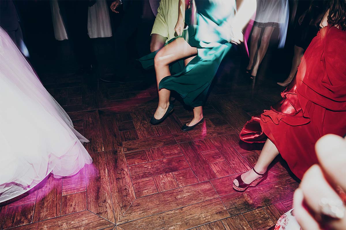  Wedding guests dancing joyfully at a decorated reception venue emphasizing the importance of choosing the right venue for a memorable first dance.