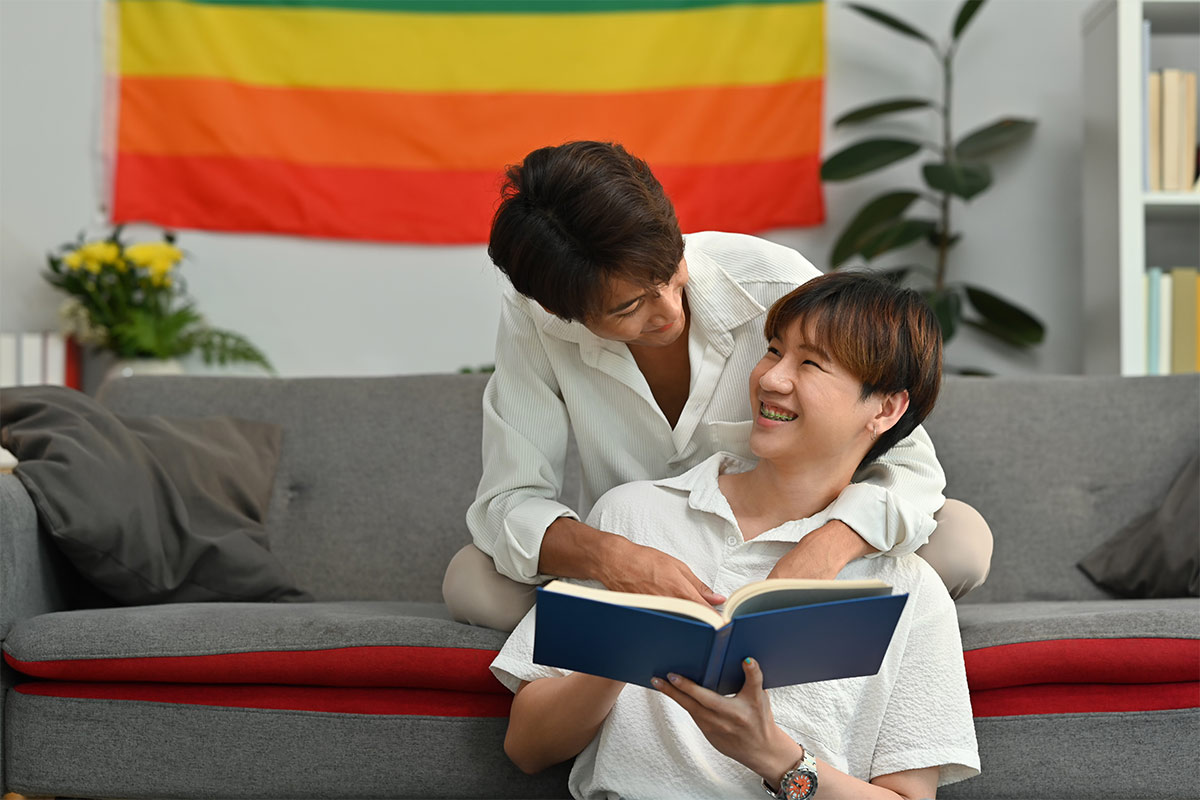 Joyful moment as two young male partners embrace each other with a book