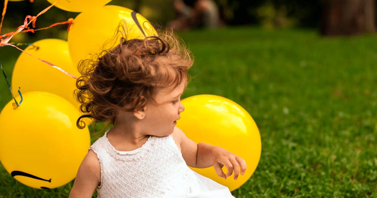 girl holding balloons