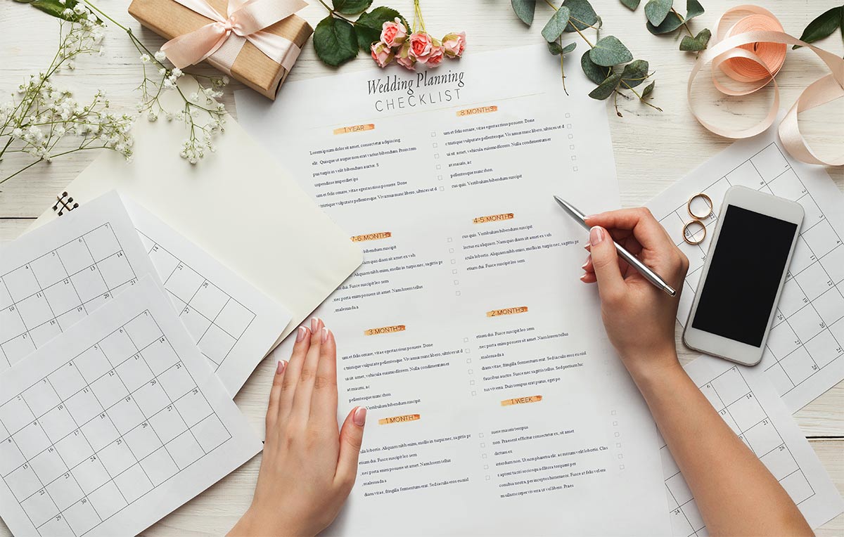 A wedding planning checklist on a desk illustrating the importance of planning in advance for a stress-free wedding