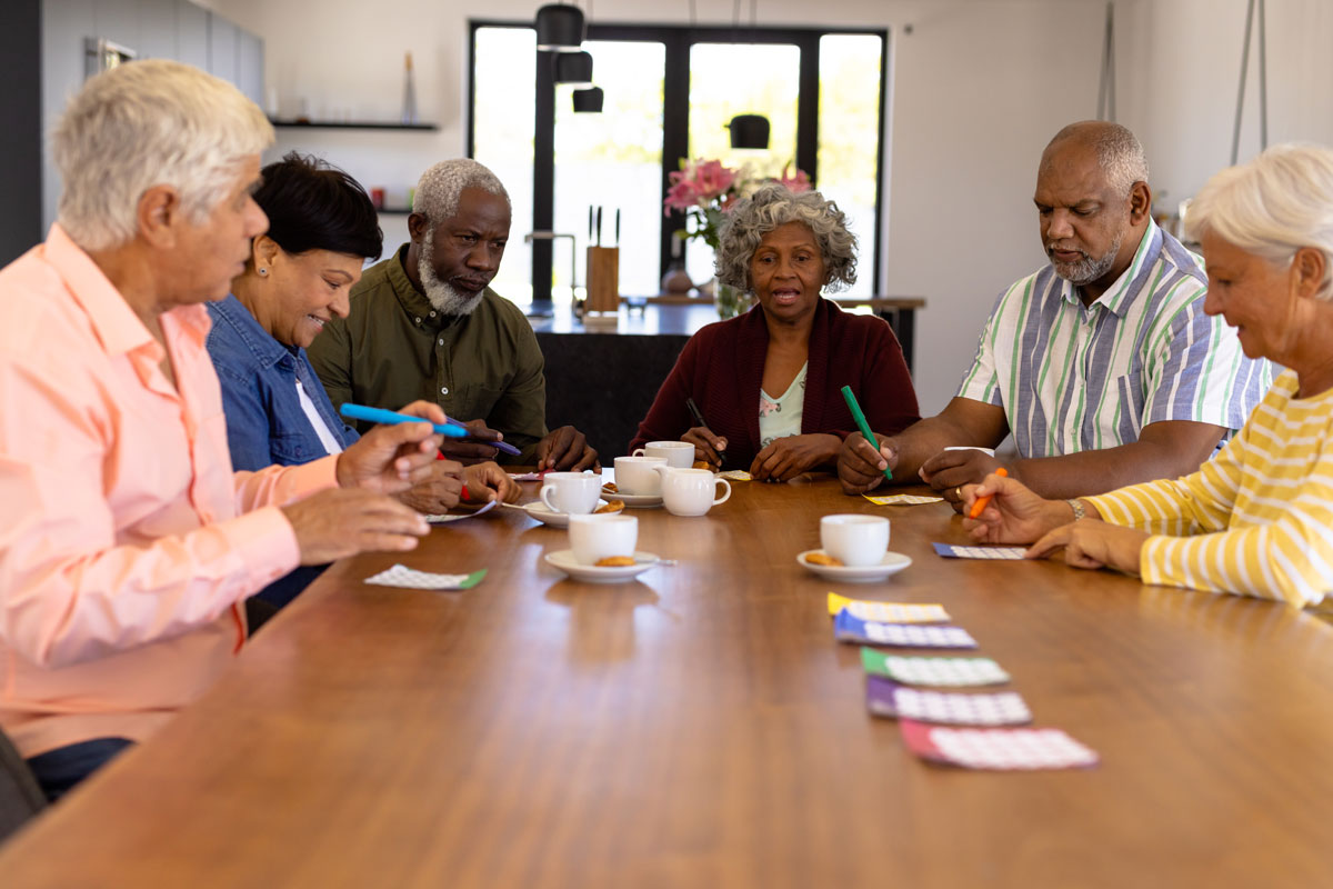 Multiracial senior friends playing bingo and laughing together