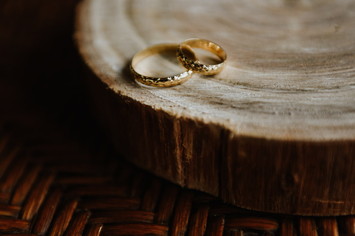 two gold bands featuring simple detailing, elegantly displayed on a wooden surface