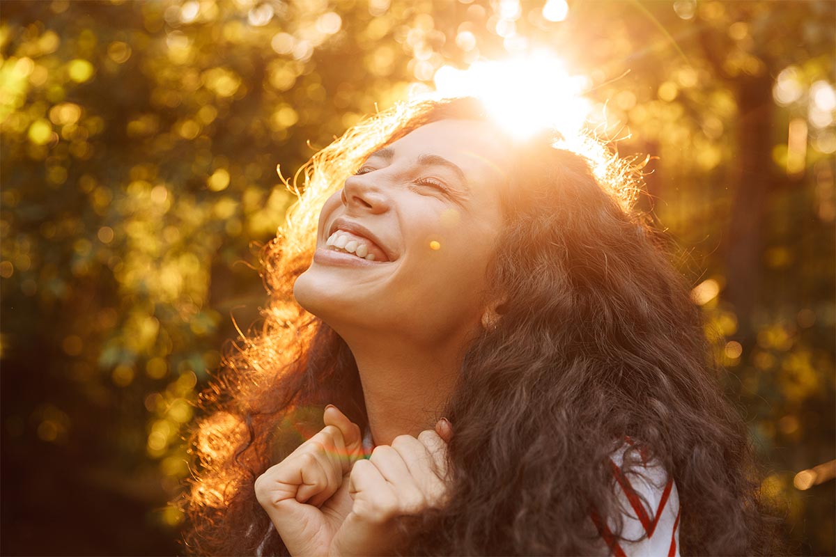 smiling young women outdoors in a forest on a sunny day