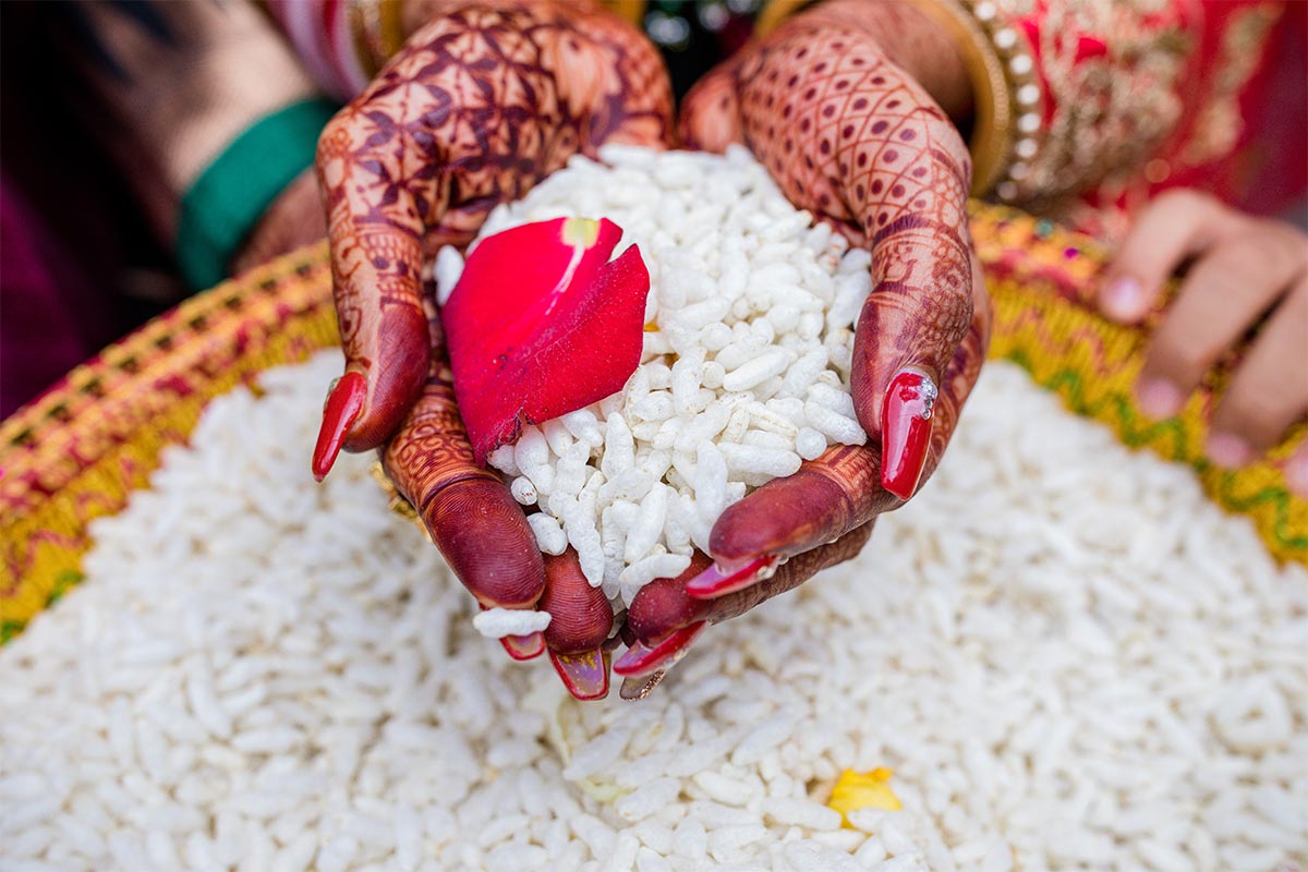 Hands with henna holding a handful of white rice