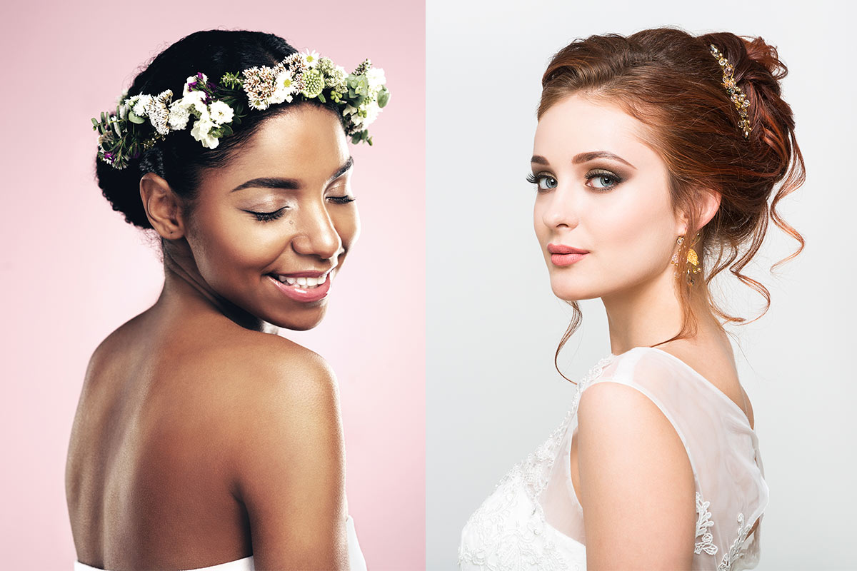 A white bride with long red brunette hair in an updo and full makeup and a black bride with a flower headpiece and her eyes closed