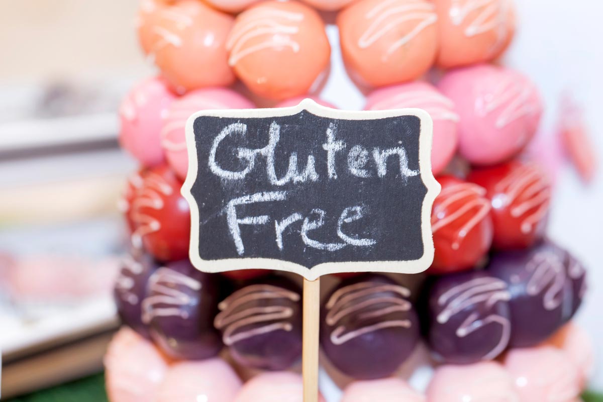 Gluten-free vegan dessert on a plate stacked high with a chalk gluten free sign in front of the desserts offering a safe option for guests with wheat allergies.