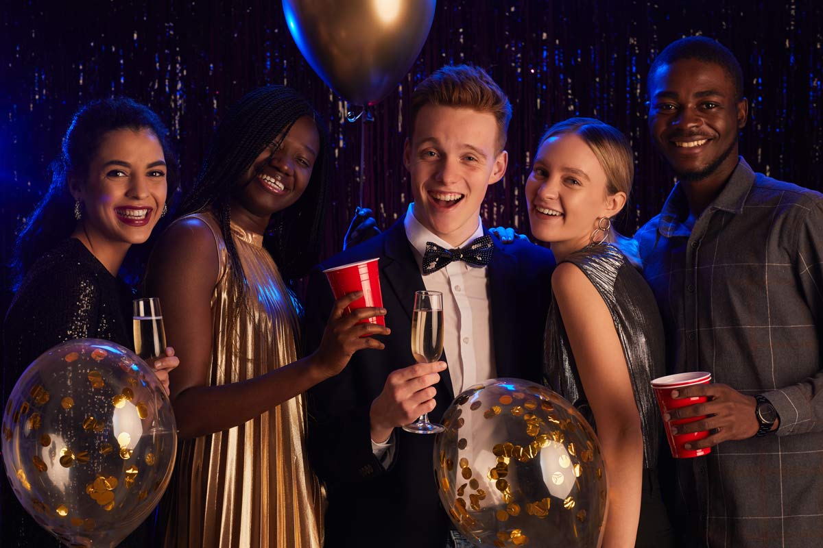 Group of five mixed-race 17-year-olds drinking sparkling juice at their senior year prom. 