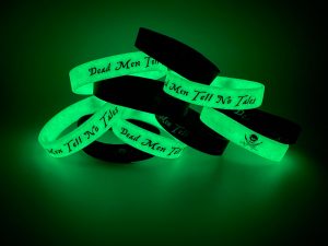 A cluster of black and green glow in the dark wristbands.
